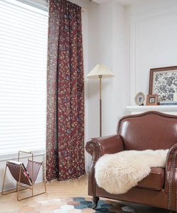 Detail of red floral and bird jacquard curtain with elegant white tassel fringe edges