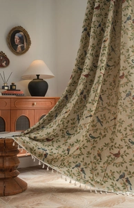 Detail showing jacquard bird patterns and white fringe on vintage beige window curtain