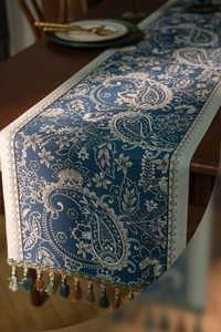Close-up of blue Paisley jacquard table runner with decorative colorful tassels