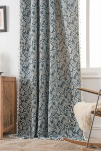 Blue palm leaf pattern blackout curtain with fringe tassels in a cozy home setting