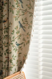 Detail view of jacquard floral and bird pattern curtain with elegant white fringe tassels