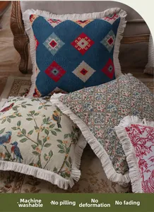 Detailed view of floral and geometric jacquard pillows with thick beige fringe tassels