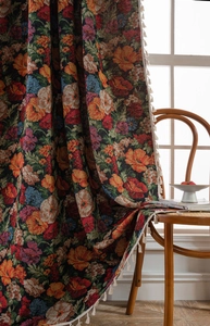 Detail of vintage floral jacquard curtain with elegant cream fringe tassels and rich texture