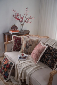 Detailed view of jacquard throw pillows with floral patterns and fringed tassel edges