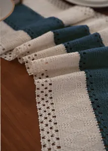 Detail showing blue and white crochet table runner with hollowed lace and fringe