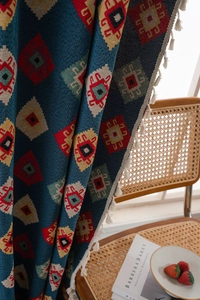 Detail of blue geometric jacquard fabric with vintage patterns and white tassel fringe