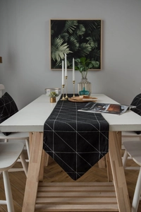 Detailaufnahme eines modernen schwarz-weißen Tischläufers mit geometrischem Dreiecksmuster
