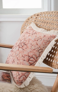 Detail of square cushion with jacquard floral patterns and thick bohemian tassels