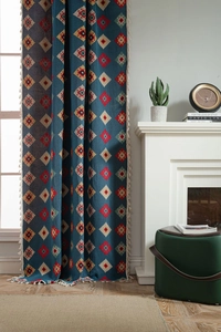 Close-up of blue geometric jacquard curtains with boho tassels in a cozy home setting