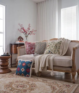 Detail of vintage French jacquard throw pillows with elegant tassel edges on a sofa