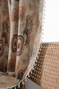 Close-up of jacquard ring pattern fabric with white fringe tassels on bohemian curtains