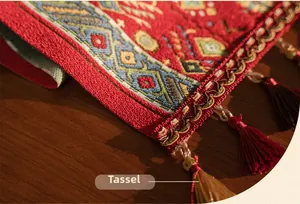 Close-up of red geometric jacquard table runner with mixed-color tassel details
