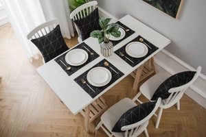 Detail von schwarzen Tischsets und Kissen mit eleganten weißen geometrischen Mustern