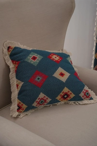 Detail of blue geometric jacquard fabric with colorful embroidery and white fringes
