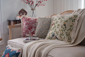 Detail of vintage American jacquard cushion covers with tassels on a beige sofa