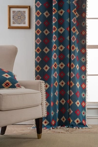Detail of blue geometric jacquard curtain with ethnic tassels in a warm home setting