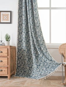Close-up of blue leaf jacquard curtain with elegant cream fringe tassels and soft linen texture
