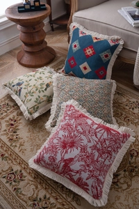 Detailed close-up of retro jacquard cushion covers with fringe edges on a vintage rug