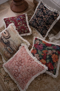 Close-up of vintage jacquard pillow covers with intricate floral patterns and fringe edges