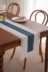 Macro detail of blue and beige woven table runner with hollow crochet and fringe trim