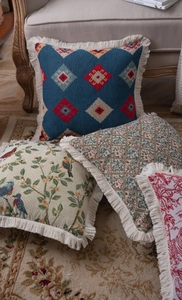 Detailed view of jacquard throw pillows with elegant fringe trim and vintage patterns