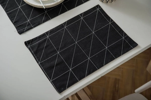 Detail eines modernen schwarzen Tischsets mit weißen geometrischen Dreiecken auf Stoff