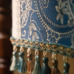 Detail of blue paisley jacquard fabric with elegant colorful hanging tassels
