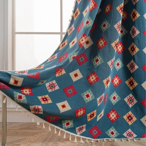 Blue geometric jacquard knit throw blanket with white tassels for cozy home decor