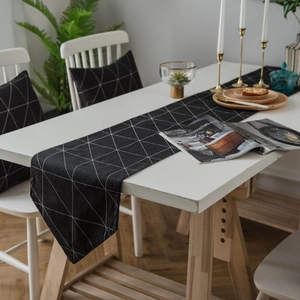 Moderner Tischläufer in Schwarz-Weiß mit geometrischem Muster und passenden Kissen