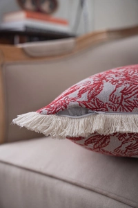 Close-up of jacquard fabric pattern with beige fringe trim and hidden zipper on cushion