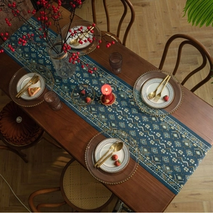 Detail van blauwe geometrische jacquard tafelloper met bohemien patronen op houtoppervlak