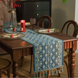 Detail van de blauwe tafelloper met geometrisch jacquardpatroon en sierlijke kwastjes