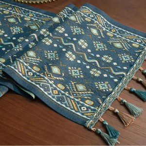 Close-up van blauwe jacquard tafelloper met geometrische patronen en kwastjes