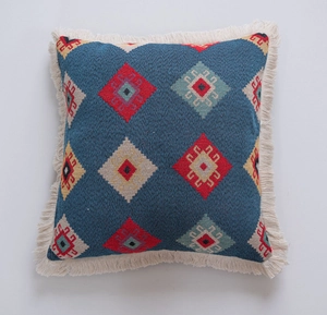 Close-up of bohemian square pillowcase with navy jacquard patterns and white tassels