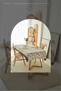 Detailed macro view of cream French floral tablecloth with elegant wavy edge design