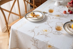 Dettaglio dell'elegante ricamo floreale dorato e bordo con nappa sulla tovaglia