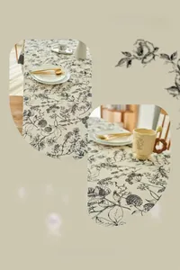 Detail of French cream style tablecloth with vintage floral patterns and scalloped edges