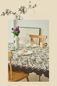 Detail of French vintage floral tablecloth with dark scalloped edges and botanical prints