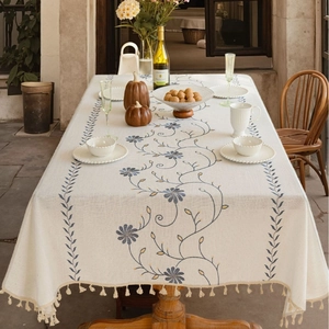 Tovaglia rettangolare in cotone lino beige con ricamo floreale blu e nappine a frangia