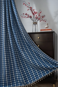 Detailed shot of retro blue and white diamond pattern curtain with cotton fringe edges