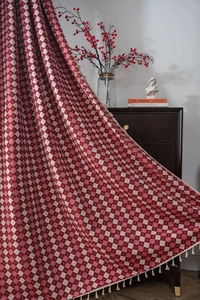 Detail of red and white checkered curtain with delicate tassel fringe in a retro room