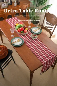 Detail of red and white checkered table runner with elegant fringe tassels on wood table