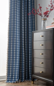 Close-up of blue diamond pattern curtain with elegant cream tassel fringe detailing