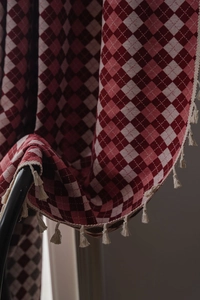 Detail of red and beige checkered jacquard fabric with elegant tassel trim decoration