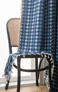 Close-up of blue and white checkered fabric with elegant white fringe tassel details