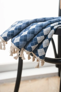 Close-up of blue argyle checkered jacquard curtain fabric with cream tassels