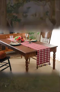 Close-up of red and white checkered table runner with decorative tassel trim and soft texture