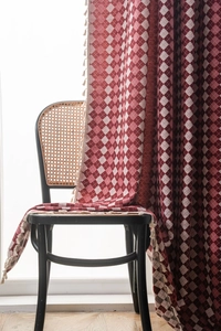 Detailed view of red and white lattice curtain fabric with elegant fringe tassels