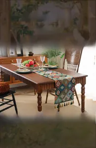 Detail of colorful geometric woven table runner with dense vintage fringe tassels