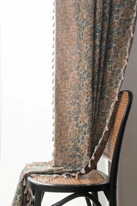 Detail of floral tapestry fabric with cream fringe tassels on a vintage chair